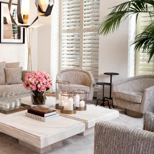 Beiger Bouclé-Sessel mit geschwungener Rückenlehne und bronzefarbenem Drehfuß – Luxushotelmöbel Lifestyle-Ansicht von Luxury Group International