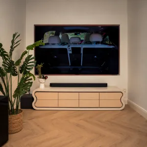 Cream Luxus Moderne TV-Einheit mit Geschwungenem Betonrahmen und Holzpaneelen – Modernes Möbelstück Lifestyle-Ansicht von Luxury Group International