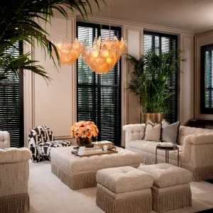 Taburete otomano de tela con textura cremosa, base con flecos y cojín mullido - Taburete de lujo Vista lifestyle por Luxury Group International