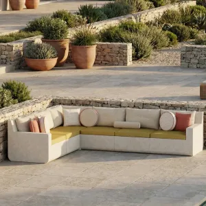 Canapé d'angle d'extérieur en béton beige de luxe avec coussins orange coucher de soleil - Mobilier d'extérieur Vue lifestyle par Luxury Group International