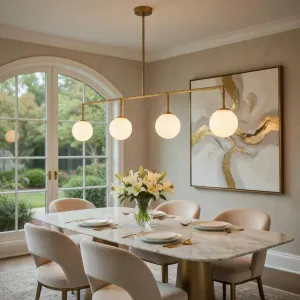 Lampada a Sospensione Lineare di Lusso con Quattro Sfere in Metallo Lucido Oro Spazzolato Vista lifestyle di Luxury Group International