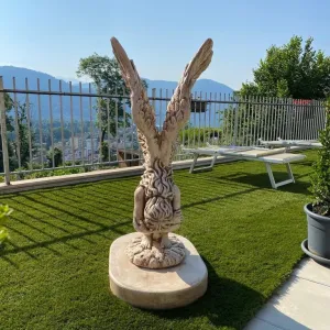 Luxury Marble Winged Garden Sculpture with Raised Feathered Wings in Natural Stone Finish Lifestyle View by Luxury Group International