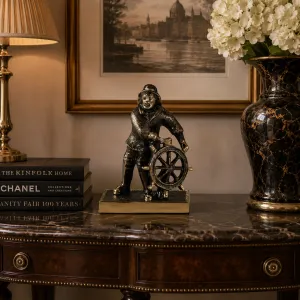 Luxus Maritime Steuermann-Bronzeskulptur mit Schiffsrad in Gold- und Oxidfinish Lifestyle-Ansicht von Luxury Group International