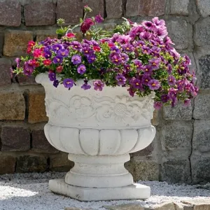Luxury Round Garden Planter with Sculpted Floral Relief and Pedestal Base Lifestyle View by Luxury Group International