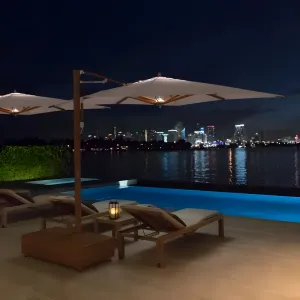 Parasol d'extérieur à bras articulé Luxury Wave avec mât latéral en bois pour patio Vue lifestyle par Luxury Group International