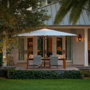Parasol déporté blanc de luxe avec mât latéral en bois pour ombrage de terrasse Vue lifestyle par Luxury Group International