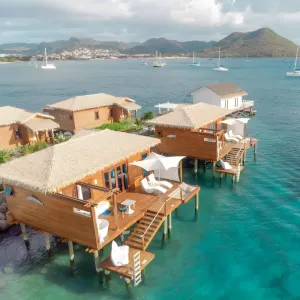 Parasol d'extérieur de luxe à voile blanche ondulée avec structure en bois pour bord de piscine Vue lifestyle par Luxury Group International