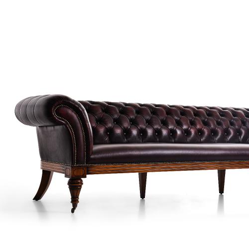 Sofá Chesterfield de Lujo en Cuero Burdeos con Respaldo Profundamente Capitoneado y Patas con Ruedas de Latón Vista detalle por Luxury Group International