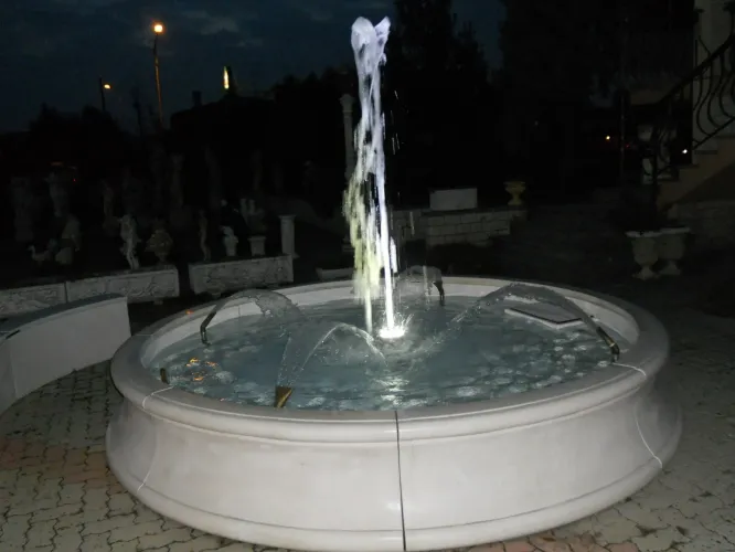 Luxury Illuminated Circular Baroque Water Fountain with Central Jet and Arc Spouts - Baroque Fountain Lifestyle View by Luxury Group International