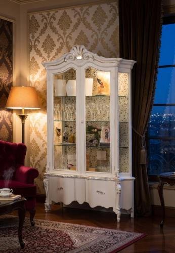 Luxury Ivory Baroque Double Door Glass Display Cabinet with Sculpted Crown Crest & Decorative Storage Base Lifestyle View by Luxury Group International