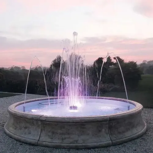 Luxus Barockbrunnen mit Steinoptik, beleuchtetem Mittelstrahl & radialen Bogenfontänen – Barockbrunnen Vorderansicht von Luxury Group International
