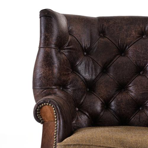 Sillón de cuero capitoné de lujo con estructura de madera de respaldo abierto y patas con ruedas de latón Vista detalle por Luxury Group International