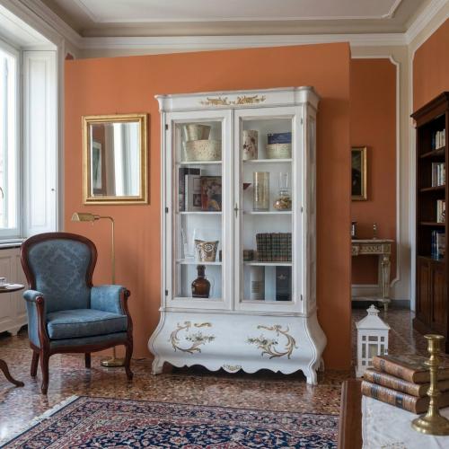 Weiß lackierter Luxus Barock Doppelglastür Vitrinenschrank mit handbemalten goldenen Akzenten - Barockmöbel Lifestyle-Ansicht von Luxury Group International